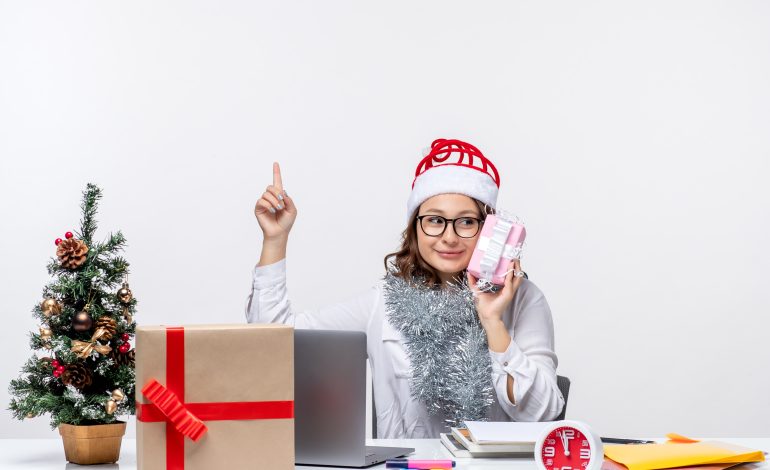 Woman in a Santa hat holding a gift, showcasing Affordable Gift Ideas.